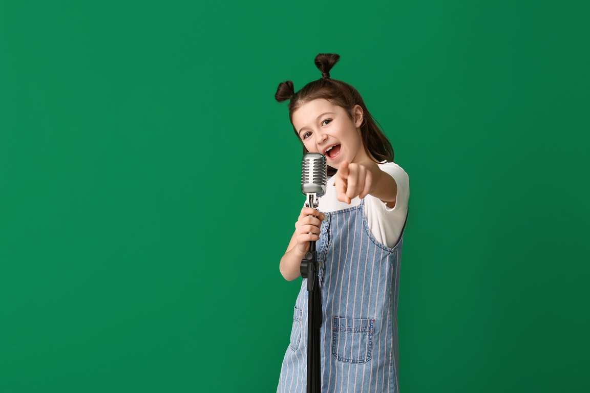 Cute Little Girl Singing against Color Background